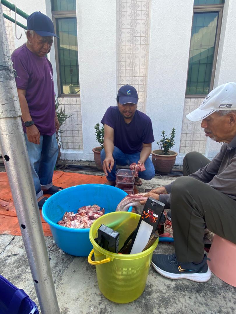 Petugas memasukkan daging korban ke dalam bekas bagi memastikan proses pembungkusan berjalan lancar.