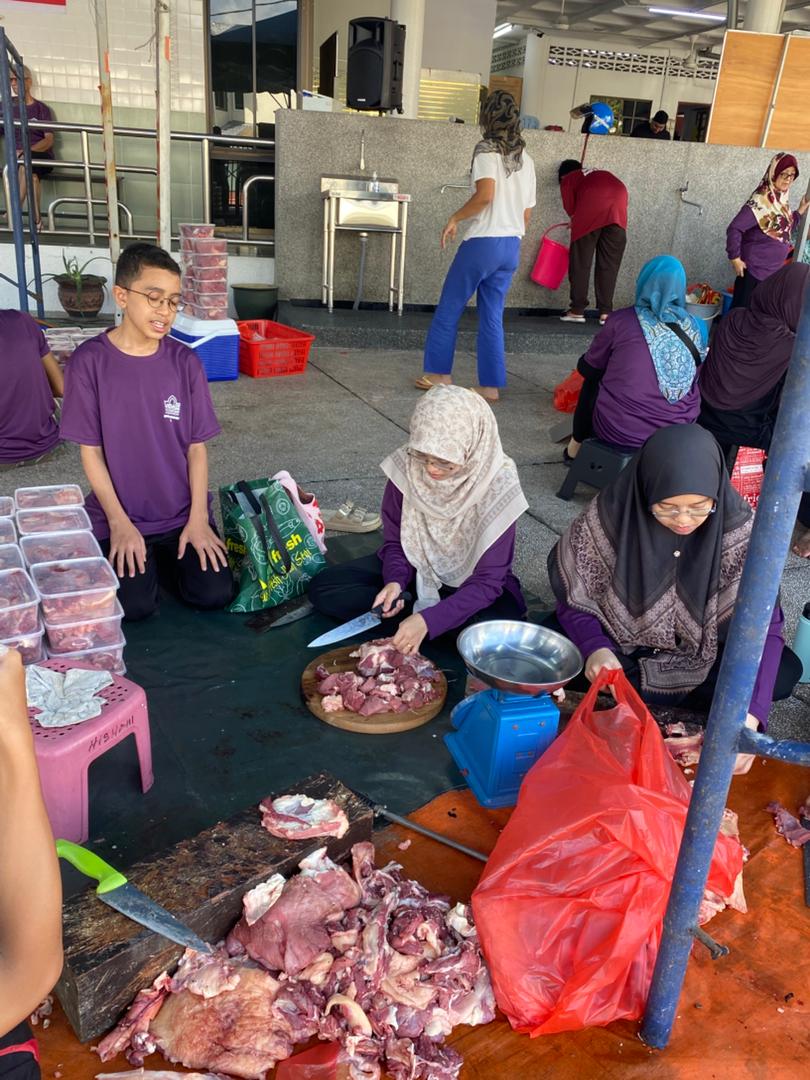 Sukarelawan membantu proses memotong dan menimbang daging korban dengan penuh kerjasama.