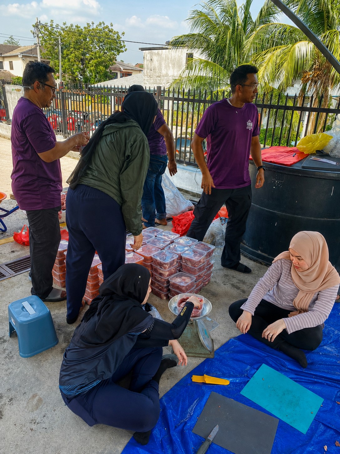Sukarelawan membantu proses menimbang dan membungkus daging korban dengan teliti.